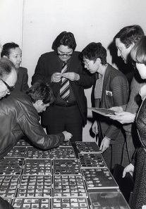 Nachdem sich die etablierten Münzhandlungen zunächst skeptisch von der neuen Sammlerschaft ferngehalten hatten, mussten auch sie sich bald der neuen Entwicklung stellen. Hier ein Bild von der Basler Münzbörse 1976, das den Börsentisch der Bank Leu zeigt. 2. von r. Dr. Alan Walker, 3. von r. Silvia Hurter. Foto: AMB.