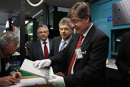 Der Finanzminister untersucht weitere Stücke auf ihre Prägung hin. Von links nach rechts: Künstler Jordi Truxa, Stellv. Münzleiter Gerd Engel, Münzleiter Dr. Peter Huber, Finanzminister BW Willi Stächele MdL. Foto: Nico Leithoff, Staatliche Münzen Baden-Württemberg.