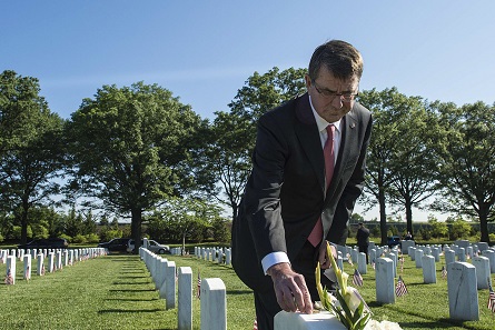 Der ehemalige Verteidigungsminister Ashton Carter legte im Mai 2015 eine Challenge Coin auf den Grabstein eines Freundes der Familie. Foto: Department of Defense, Sean Hurt.