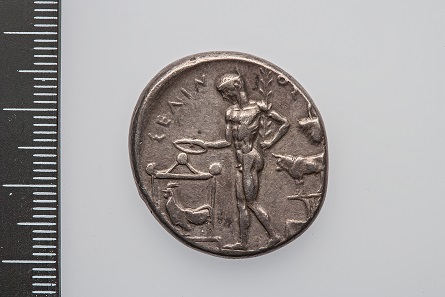 Nacktheit ist in der antiken Bildsprache oft mit religiösen Handlungen verbunden wie hier auf dieser Tetradrachme aus Selinunt (Hochklassik, Gewicht: 17.35 g; Durchmesser: 28.4 mm, Silber). Der jugendliche Flussgott Selinos opfert aus einer Schale mit einem Lorbeerzweig in der Hand. © Antikenmuseum Basel.